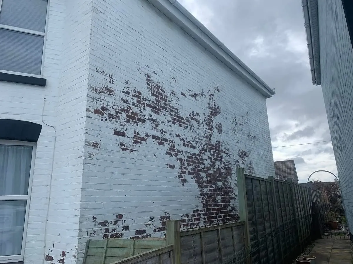 Peeling paint on a brick wall before redecoration in Ilfracombe